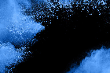 Bizarre forms of  blue powder explode cloud on black background. Launched blue dust particles...