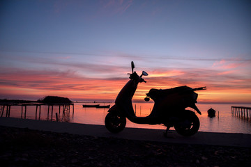 A scooter silhouette at sunrise