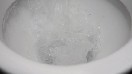 White toilet paper is flushed down the toilet.
