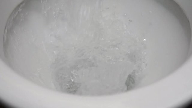 White toilet paper is flushed down the toilet.
