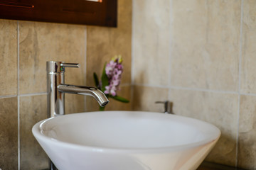 cuarto de baño deceración interior con griferia plateada y tarja en color blanco, luz suave