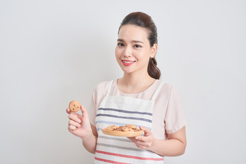 Young woman holding a plate of homemade chocolate cookies