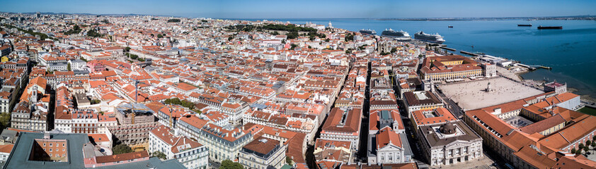 Fototapeta premium Aerial drone panorama photo - Colorful orange roofs of the Alfama district & the Comercio Square (Praça do Comércio) of Lisbon Portugal