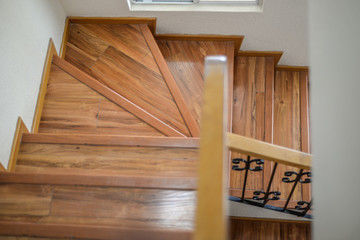 escaleras interiores con barandal negro, cubiertas de piso laminado madera