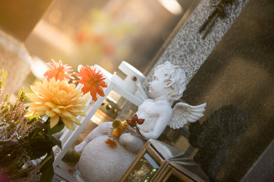 Marmoreal white Angel at the cemetery, sorrow, sunlight