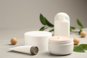 Obraz na płótnie Canvas Jars with cream and bottles on light table. Hand care cosmetics