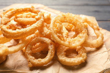 Homemade crunchy fried onion rings on cutting board, closeup