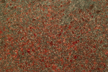 Background, natural texture - the mottled surface of a red-gray granite slab..