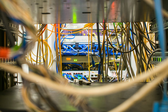 Many wires are in the rack with the switching equipment of the Internet provider. The communication cables and fiber optic patch cords are located in the switching cabinet. Selective focus