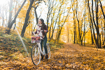 Plakat selective focus of happy girl in leather jacket and beret riding on bicycle in yellow autumnal forest