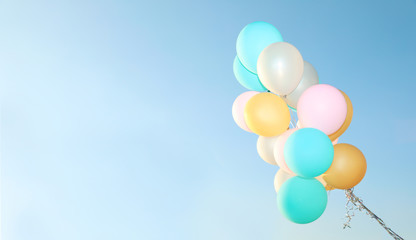 Bunch of colorful balloons against clear blue sky. Space for text