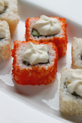 Traditional japanese seafood, roll are lying on a white plate. Close up.