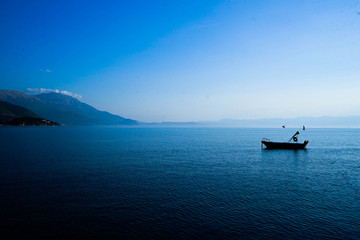 A boat sits peacefully on lake Orhrid Macedonia in late summer