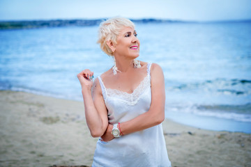 Fototapeta na wymiar woman in white dress look on the sea