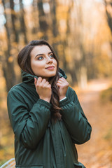 selective focus of beautiful young woman in jacket posing outdoors