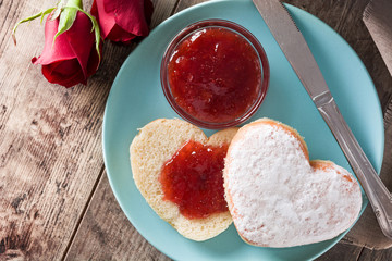 Valentine's Day breakfast with coffee, heart-shaped bun and berry jam. Top view

