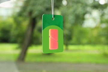 Air freshener hanging in car against windshield