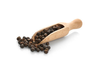 Wooden scoop with black pepper grains on white background