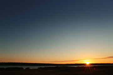 Fototapeta na wymiar Picturesque view of beautiful sunrise on riverside. Morning sky