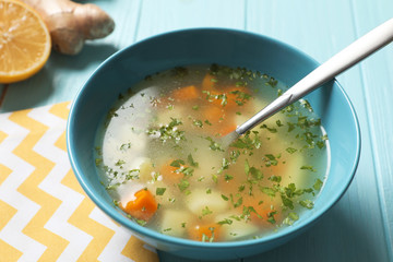 Bowl of fresh homemade soup to cure flu on wooden table