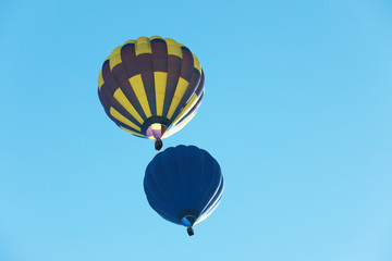 Fototapeta premium Colorful hot air balloons flying in blue sky. Space for text