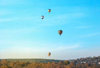 Colorful hot air balloons flying over countryside