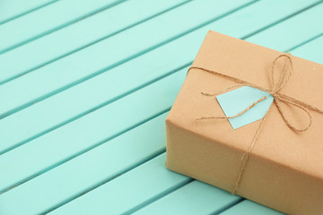 Parcel with tag on wooden background. Space for text