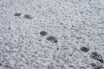 footprints in the snow on the pavement