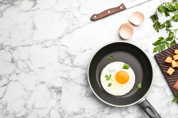 Pan with fried sunny side up egg served on table, flat lay with space for text