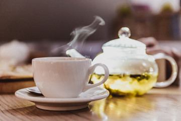 Cup of hot aromatic tea with steam and kettle, green, fruit tea