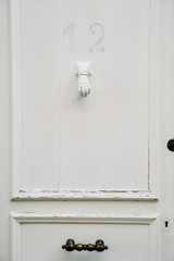 Vintage door knob in a form of a hand on wooden door