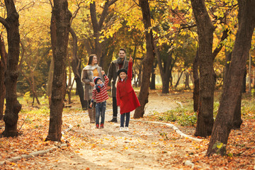 Happy family with children spending time together in park. Autumn walk