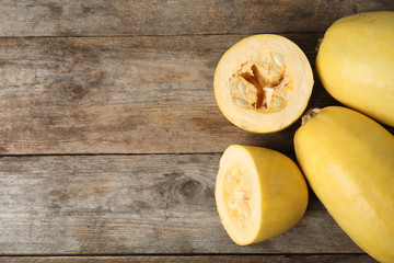 Whole and cut spaghetti squashes on table, top view with space for text