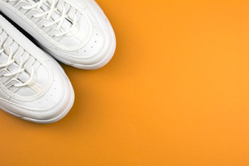 Sneakers. Equipment for running. Fitness and sport concept. top view copy space, orange background.