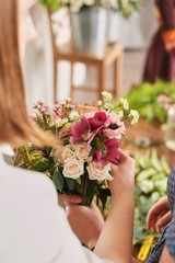 hands of florist collect wedding bouquet at work