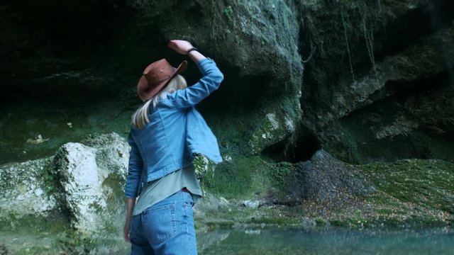 young beautiful caucasian girl traveler is walking along a tropical cave. Inspired by the beauty of nature. Looking for adventure in exotic places of the planet. Active lifestyle.
