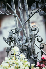 Iron sculpture at cemetery, tombstone and flowers