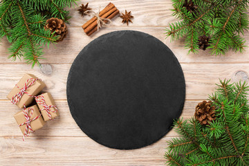 Empty Slate plate on table with christmas decoration. black slate stone on wooden background. copy...