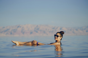 brunette girl swimming in the dead sea