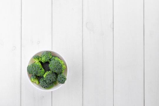 Bowl of broccoli parts onthe wooden background