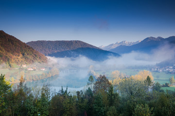 Mist over Most na Soci river with Julian Alps in Background, Slovenia