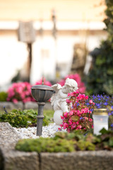 Angel at Cemetery, grave with open book out of, flowers