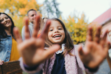 A portrait of young family with two small children in autumn nature.