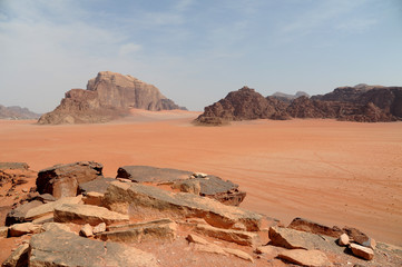 Fototapeta na wymiar Red mountains of the canyon of Wadi Rum desert in Jordan. Wadi Rum also known as The Valley of the Moon is a valley cut into the sandstone and granite rock in southern Jordan to the east of Aqaba