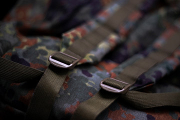 Military camouflage roomy backpack. In the frame of the strap and the back of a backpack. Close-up view.