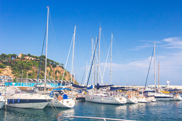 Fototapeta na wymiar Sail Boats and yachts parked at docks of Blanes, Costa Brava, Spain