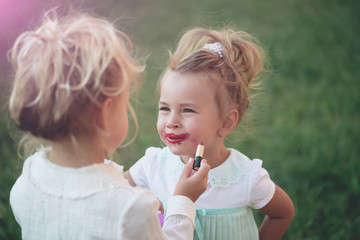 Baby apply red lipstick on lips of kid model