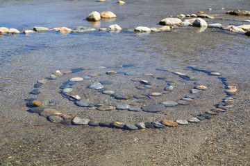Spirale aus  zusammen gesetzten Steinen im Wasser, esoterisch
