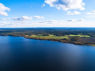 Fototapeta premium Aerial view of seashore with beach, lagoons. Coastline with sand and water. Landscape. Aerial photography. Birdseye. Sky, clouds. Stunning sky clouds. Sky landscape.