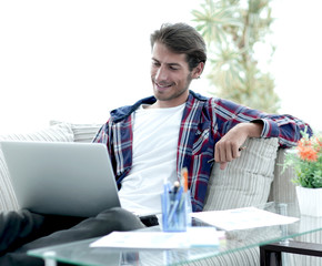 happy guy working with laptop from home. concept of freelancing.